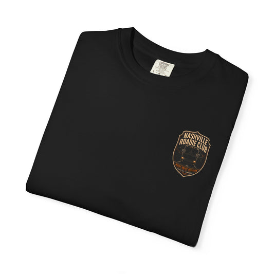 Folded black Night Drive Division T-shirt showing the amber tour bus badge and Nashville Roadie Club lettering.