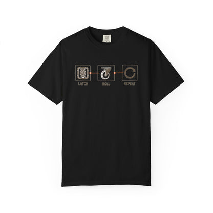 Front of a black Latch Roll Repeat T-shirt with road-case latch and caster graphics.